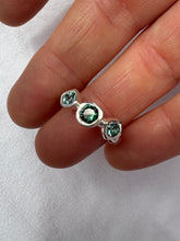 Load image into Gallery viewer, Silver and green tourmaline ring held in fingers on white background.