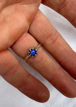 Load image into Gallery viewer, Silver ring with a blue gemstone on a finger against a white background