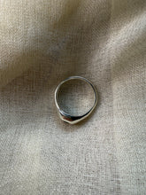 Load image into Gallery viewer, Silver ring on a textured beige fabric background